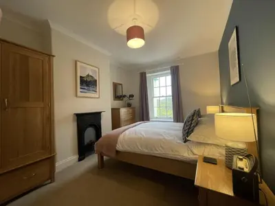 a bedroom with a bed and a fireplace at Fell View in Portinscale