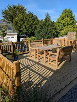 a wooden table and benches on a wooden deck at Fell View in Portinscale