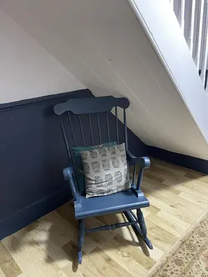 a blue rocking chair with a pillow on a staircase at Stunning 2-bedroomed Cottage in Cockermouth