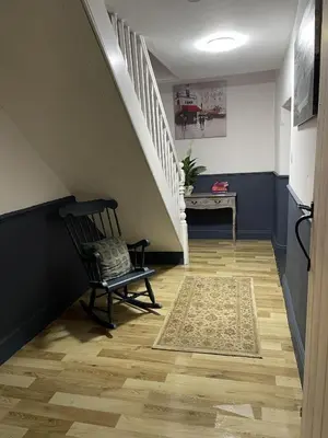 a hallway with a chair and stairs with a rug at Stunning 2-bedroomed Cottage in Cockermouth