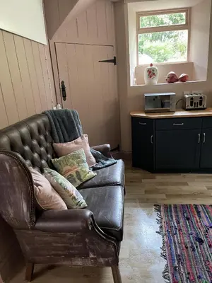 a leather couch with pillows on it in a living room at Stunning 2-bedroomed Cottage in Cockermouth