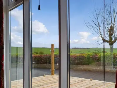 a window with a view of a wooden deck at Forrest Lodge in Plumbland