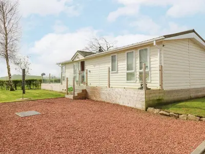 a white house with a gravel driveway in front of it at Plot 32 in Carlisle