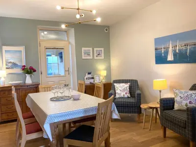 a dining room and living room with a table and chairs at Laurel Bank House in Penrith