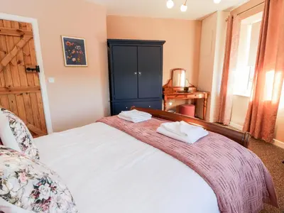 a bedroom with a bed with two towels on it at Smithy House in Dumfries