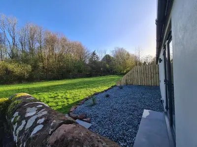 a door of a house with a fence and a yard at The Nest by Blake view holidays, a peaceful boutique retreat, 3 miles from Ennerdale- small twin or king bed available in Rowrah