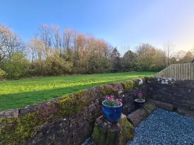 a stone retaining wall with two potted plants on it at The Nest by Blake view holidays, a peaceful boutique retreat, 3 miles from Ennerdale- small twin or king bed available in Rowrah