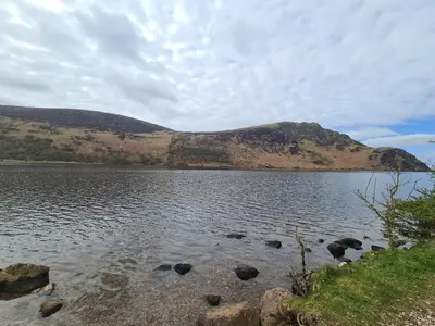 a large body of water with a mountain in the background at The Nest by Blake view holidays, a peaceful boutique retreat, 3 miles from Ennerdale- small twin or king bed available in Rowrah