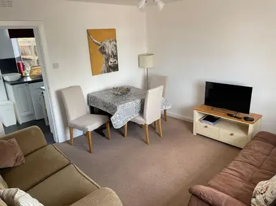 a living room with a table and a couch at Odea Hot tub Holiday Cottage in Dumfries