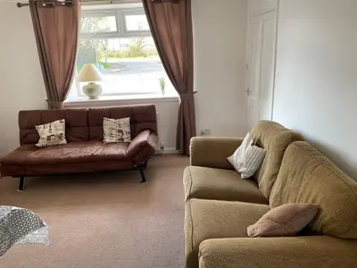 a living room with a couch and a window at Odea Hot tub Holiday Cottage in Dumfries