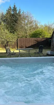two chairs sitting next to a pool of water at Odea Hot tub Holiday Cottage in Maxwelltown