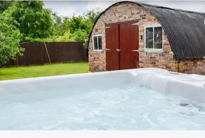 a large pool of water in front of a building at Odea Hot tub Holiday Cottage in Maxwelltown