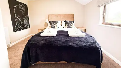 a bedroom with a large bed with a black blanket at Wheyrigg Hall Hotel in Wheyrigg