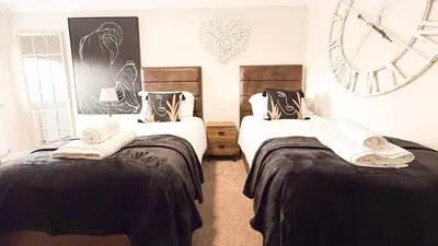 a bedroom with two beds and a clock on the wall at Wheyrigg Hall Hotel in Wheyrigg