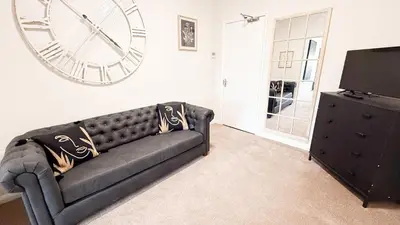 a living room with a couch and a clock on the wall at Wheyrigg Hall Hotel in Wheyrigg