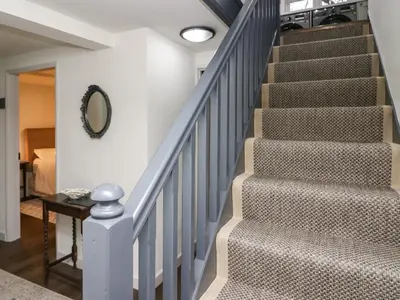 a staircase in a home with a round mirror at The Barn in Seascale
