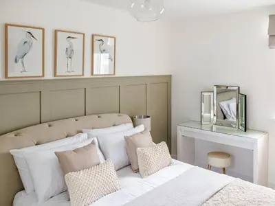 a bedroom with a white bed with pillows on it at Flag Cottage in Carsethorn