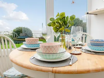 a table with bowls and plates on top of it at Flag Cottage in Carsethorn