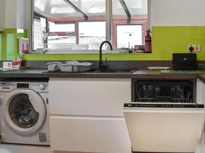 a kitchen with a washing machine and a sink at Teazles in Peel