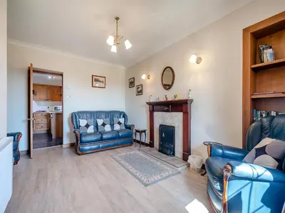 a living room with blue furniture and a fireplace at Kilbride Cottage-Uk46886 in Kilmory
