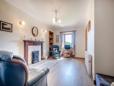 a living room with a couch and a fireplace at Kilbride Cottage-Uk46886 in Kilmory