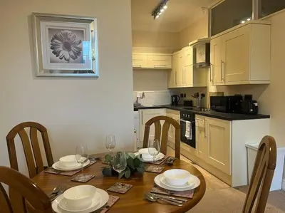 a kitchen with a wooden table with chairs and a dining room at Thurnams House, Ground Floor Apt in Carlisle