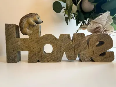 a wooden figurine of a hedgehog on top of a wordarma at Thurnams House, Ground Floor Apt in Carlisle