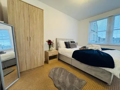 a bedroom with a large bed and a mirror at Curwen Apartment - 2 Bedrooms - Sleeps 6 in Workington