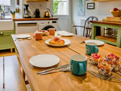 a wooden table with plates and cups and food on it at 3 Bed in Cockermouth oc-94928 in Cockermouth