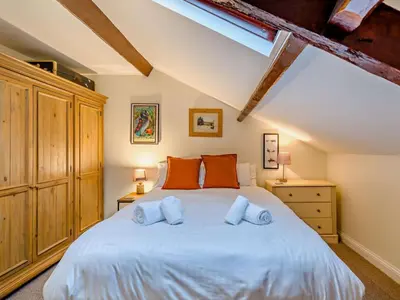 a bedroom with a large white bed with orange pillows at 3 Bed in Cockermouth oc-94928 in Cockermouth