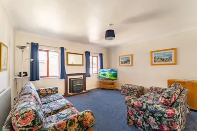 a living room with two couches and a tv at Lakeland Nook in Keswick