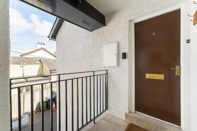 a black door on a balcony with a view of a building at Lakeland Nook in Keswick