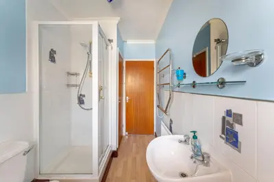 a bathroom with a sink and a shower and a mirror at Lakeland Nook in Keswick