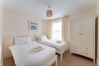 two white beds in a room with a window at Ratstone Cottage in Keswick
