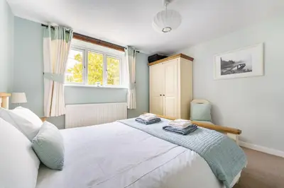 a bedroom with a white bed and a window at The Mews in Keswick