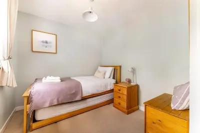 a bedroom with a bed and a wooden dresser at The Mews in Keswick