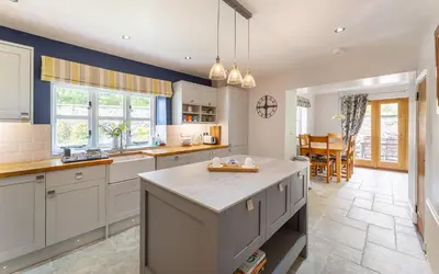 a kitchen with white cabinets and a large island at The Mews in Keswick