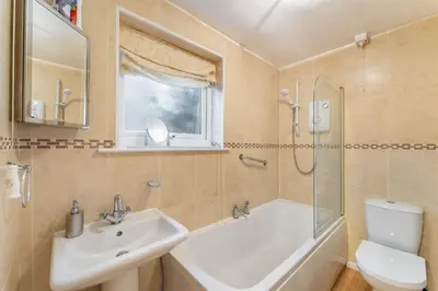 a bathroom with a sink and a tub and a toilet at Sunny Cottage in Keswick