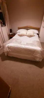 a bedroom with a bed with white sheets and pillows at The White Heather Hotel in Wigton