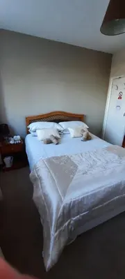 a bedroom with a bed with white sheets and pillows at The White Heather Hotel in Wigton
