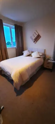 a bedroom with a large white bed with a window at The White Heather Hotel in Wigton