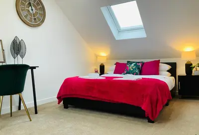 a bedroom with a large bed with a red blanket at Harling House - Prestwick - 4 bedrooms in Prestwick