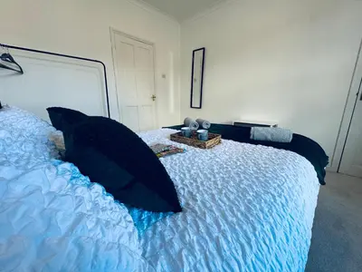 a bedroom with a large bed with black pillows at Cumberland House-2 Bedrooms - Sleeps 4 in Workington