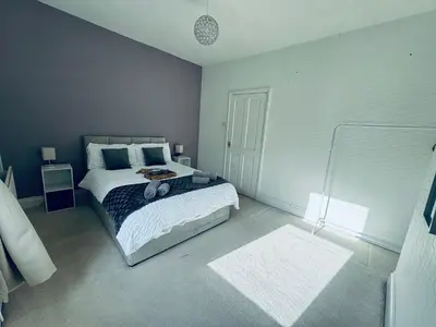a bedroom with a large bed with blue and white at Cumberland House-2 Bedrooms - Sleeps 4 in Workington