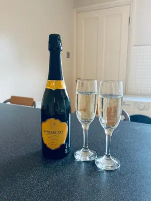a bottle of champagne and two glasses on a table at Cumberland House-2 Bedrooms - Sleeps 4 in Workington