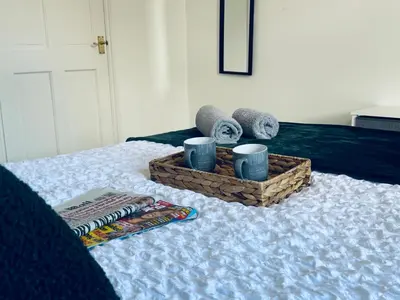 a bed with a tray of towels and a basket of towels at Cumberland House-2 Bedrooms - Sleeps 4 in Workington