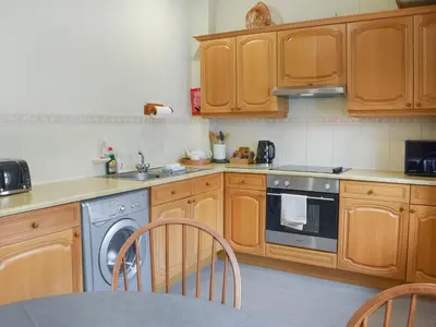 a kitchen with wooden cabinets and a dishwasher at Courtyard View in Keswick