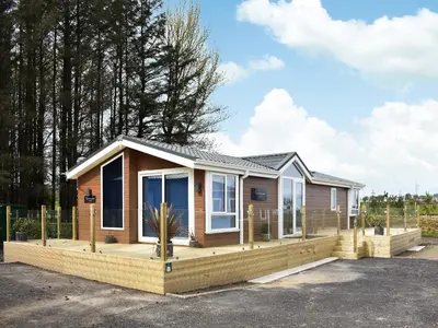 a small house with a large deck at Solway Escape in Plumbland