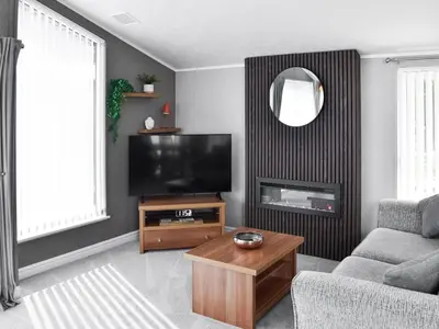 a living room with a television and a table at Solway Escape in Plumbland