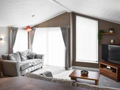 a living room with a couch and a tv at Solway Escape in Plumbland